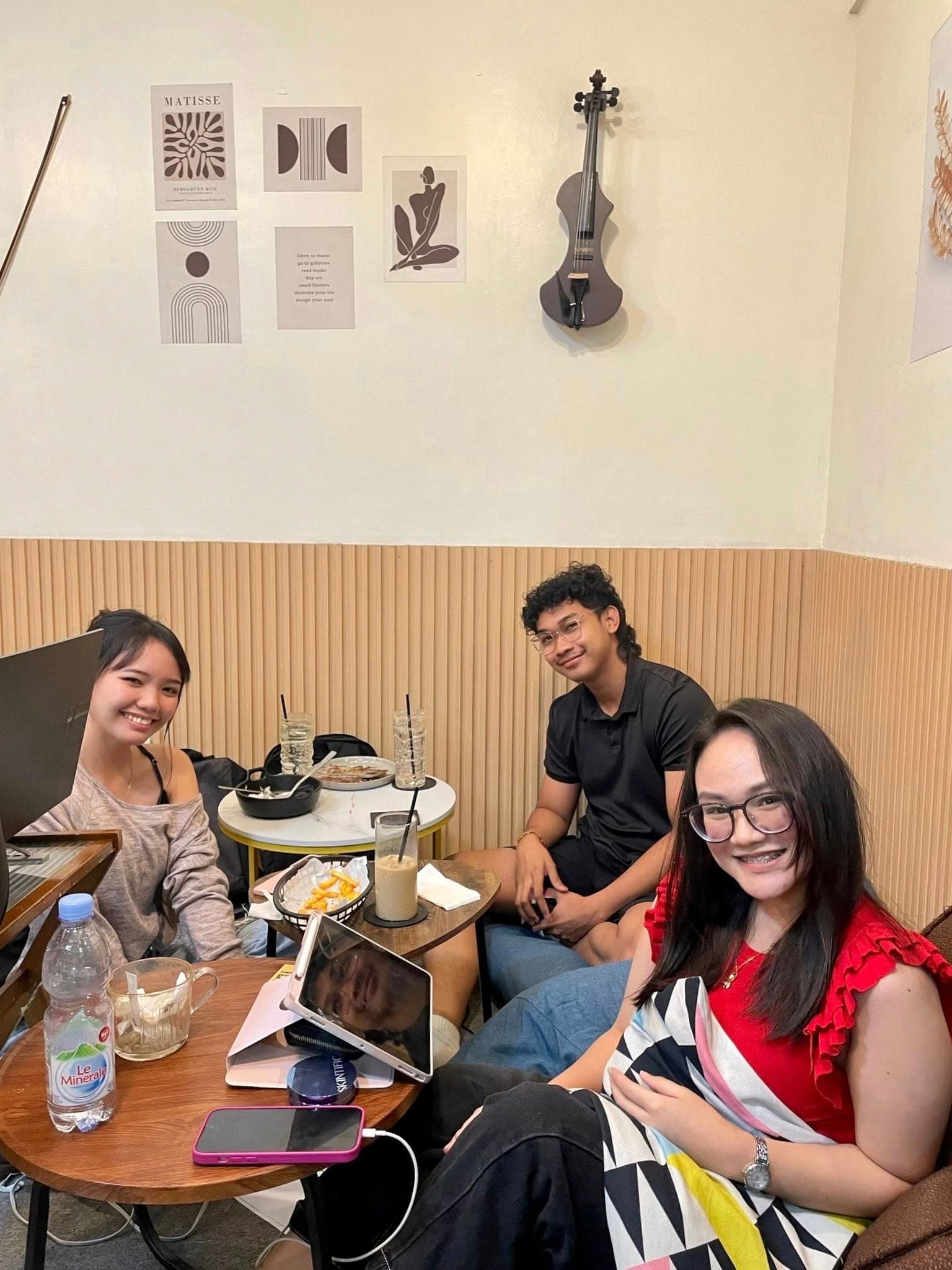 Friends smiling at a cafe table inside WeeCup